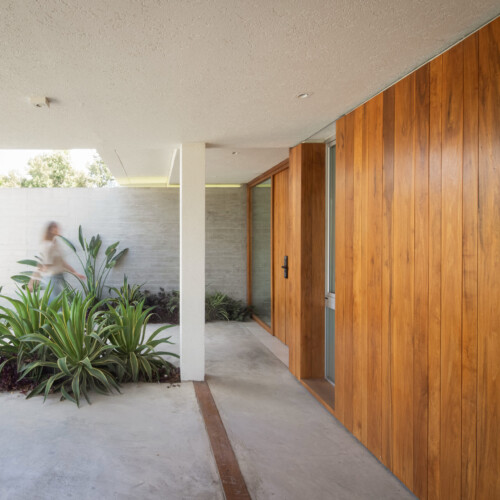 Casa con patio interior en nordelta, ingreso con hormigón y madera natural
