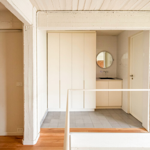 Remodelación de departamento tipo loft en CABA estilo industrial y moderno. Estar comedor con doble altura. Materiales de ladrillo visto, madera y herrería. Baño en acero inoxidable